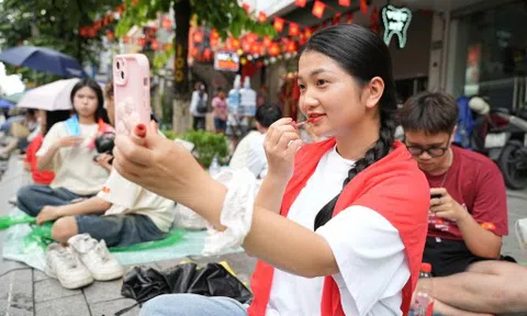 Nhiều bạn trẻ tranh thủ học bài, trang điểm trên vỉa hè chờ diễu binh, diễu hành